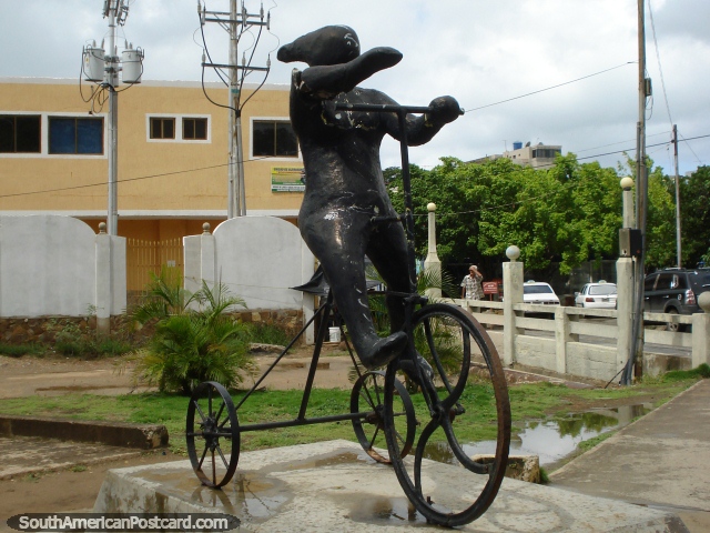 A escultura metálica em Juan Griego de um figura que monta uns 3 rodou a bicicleta, Ilha Margarita. (640x480px). Venezuela, América do Sul.