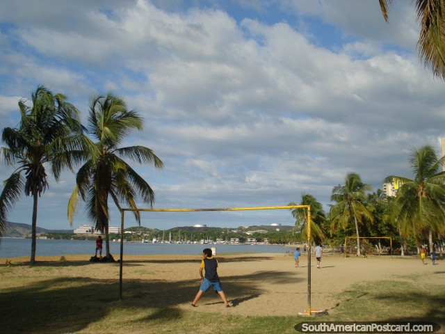 Pessoas que jogam futebol na metade de arremesso classificado no fim ocidental da praia em Porto La Cruz. (640x480px). Venezuela, América do Sul.