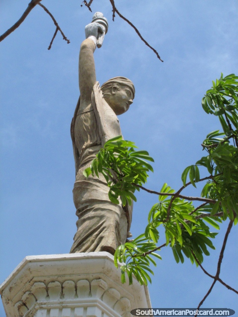 O homem mantém a tocha em cima do monumento de Praça Libertad em Maracaibo. (480x640px). Venezuela, América do Sul.