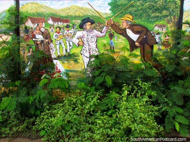 Pintura mural de una escena del pueblo con 2 hombres que luchan con bastones en El Tintorero. (640x480px). Venezuela, Sudamerica.