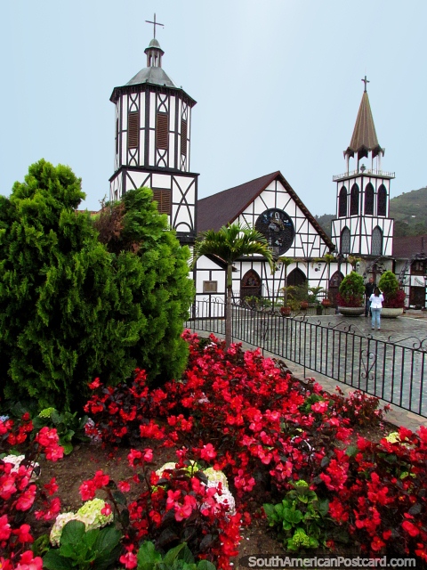 Red flower gardens and the new church at Plaza Bolivar in Colonia Tovar. (480x640px). Venezuela, South America.