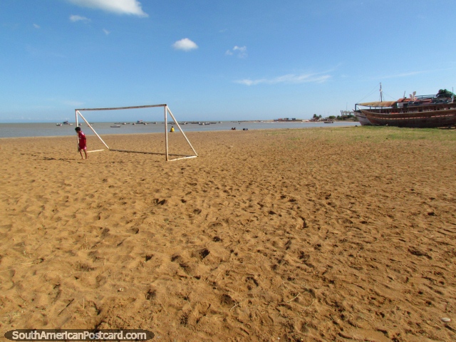 Boy stands in a goal on the sand at the beach in Coro - La Vela de Coro. (640x480px). Venezuela, South America.