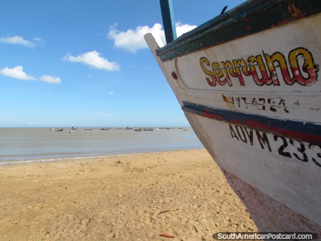 Um barco de pesca na areia indica a outros barcos de pesca na água em La Vela de Coro. (640x480px). Venezuela, América do Sul.