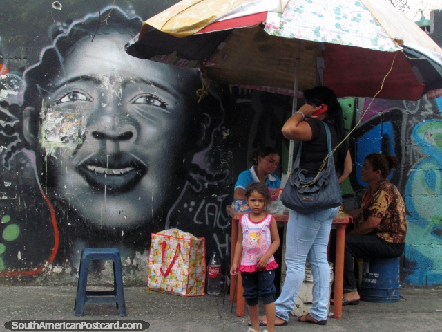 As meninas enfrentam a arte de grafite junto da senhora telefônica de Acarigua. (640x480px). Venezuela, América do Sul.