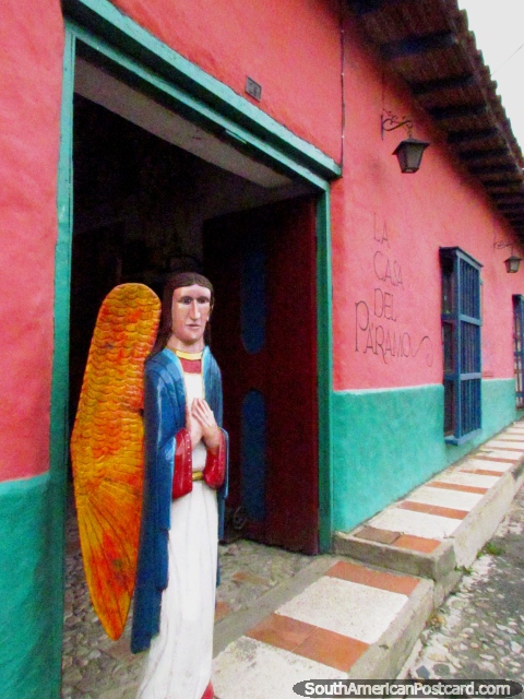 An angel with wings figure stands outside the pink 'Casa del Paramo' in San Isidro de Apartaderos. (480x640px). Venezuela, South America.